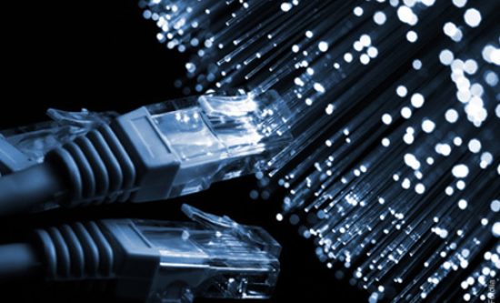 Câbles Ethernet RJ45 connectés à des fibres optiques lumineuses.